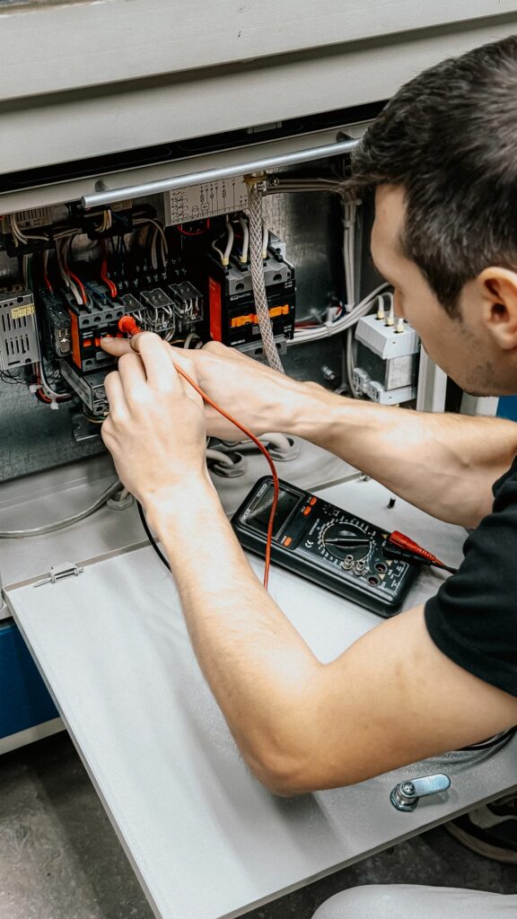 Elettricista che controlla un quadro elettrico con il tester